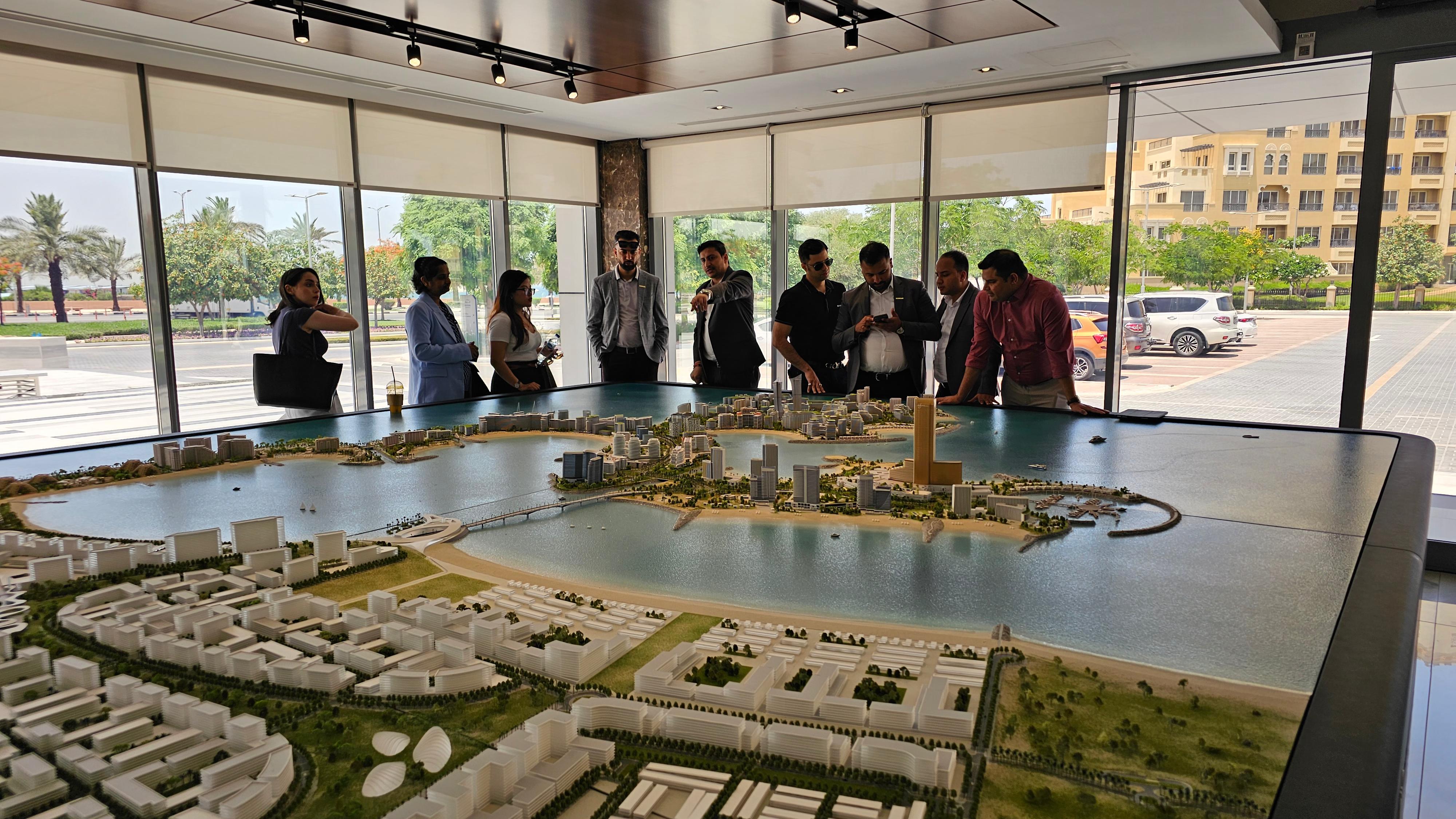 Two professionals in business attire discussing legal documents with a laptop, a gavel, and scales of justice on the table