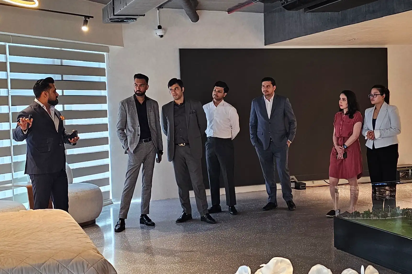 Two professionals in business attire discussing legal documents with a laptop, a gavel, and scales of justice on the table